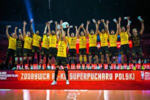 Sur le podium, les joueurs de Lublin célèbrent leur victoire, menés par leur passeur Marcin Komenda, qui soulève le trophée de la Supercoupe sous les applaudissements du public. (PlusLiga)